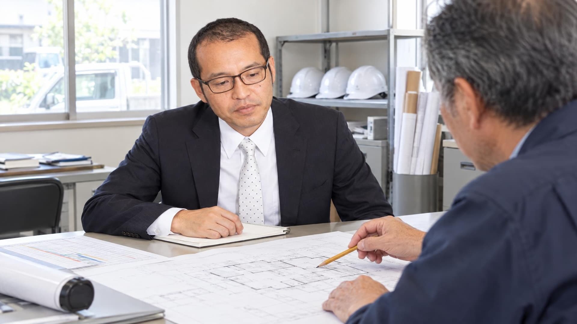 工務店の事務所で社長と図面を確認する嶺本高志